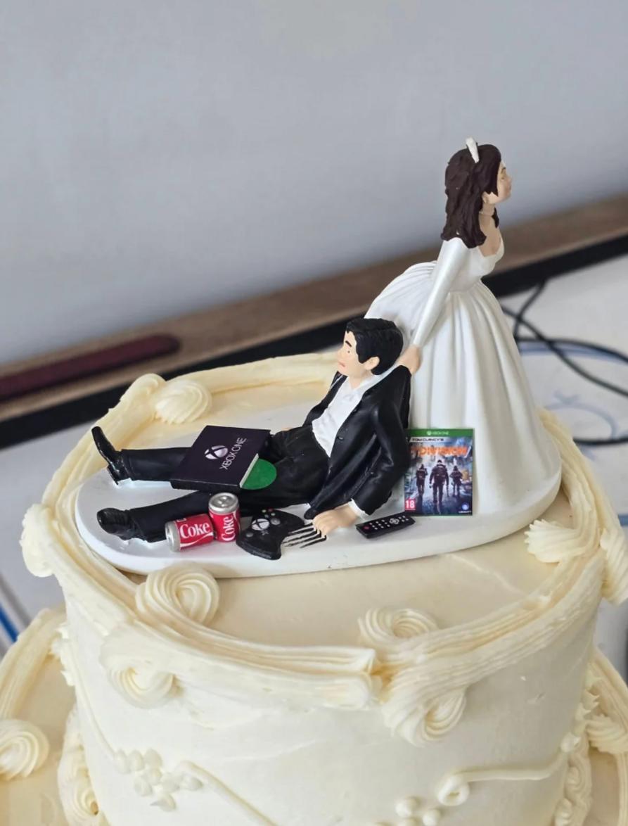 Figura de tarta de novia arrastrando a novio gamer