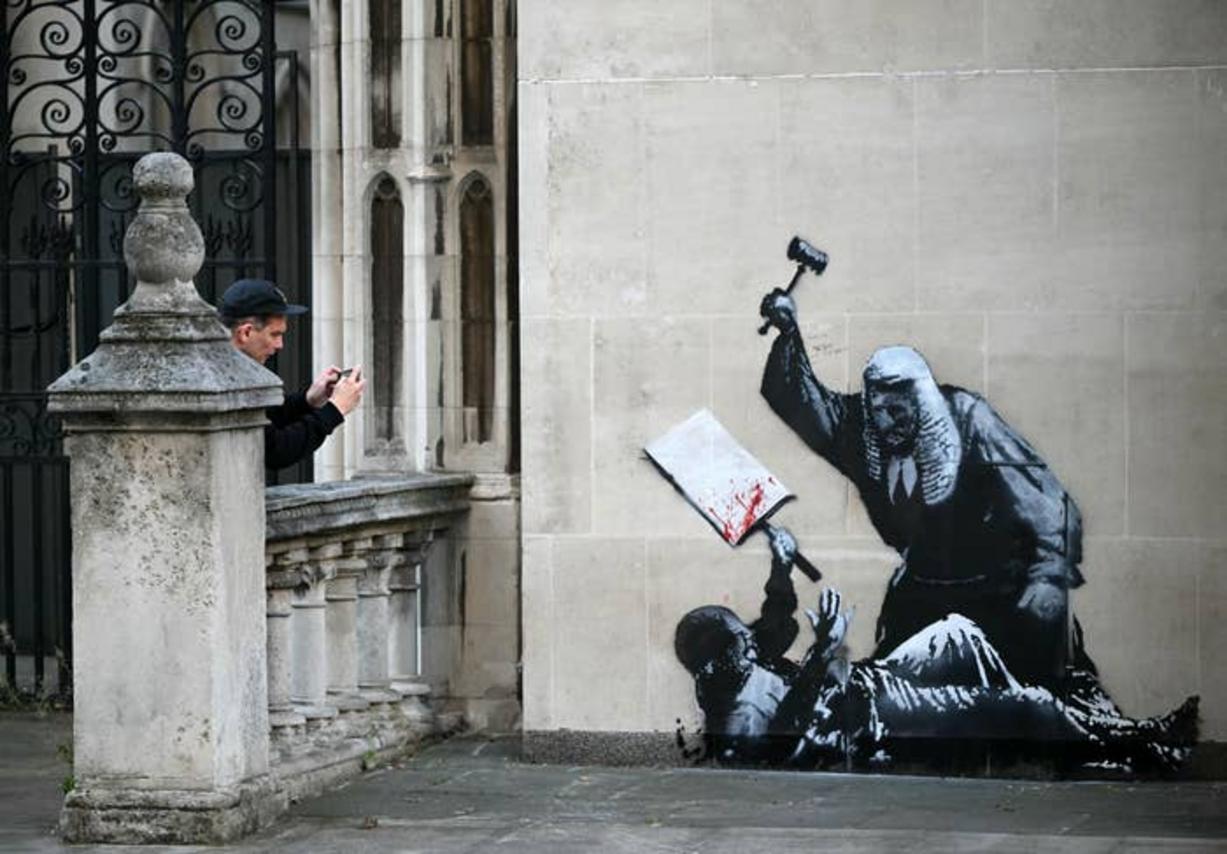 Mural de Banksy de un juez golpeando a una figura
