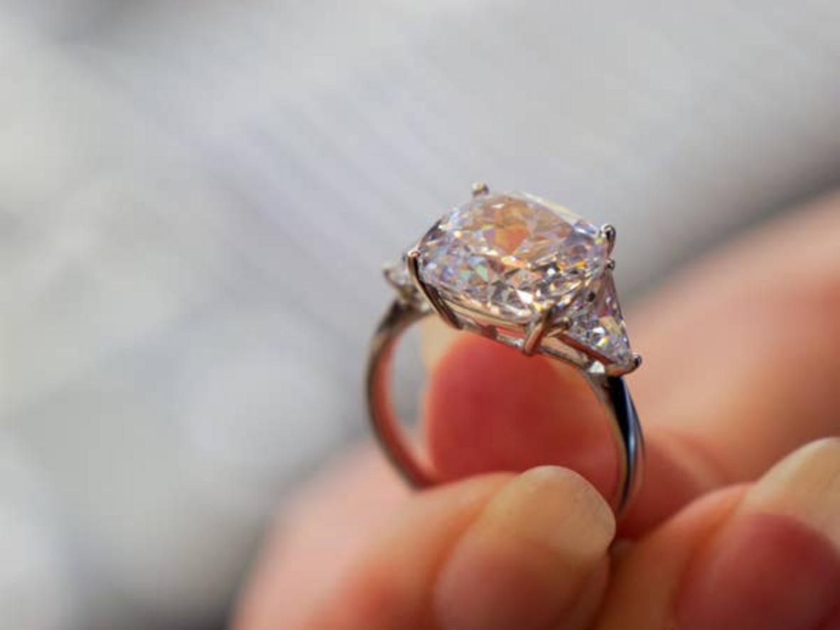 Mano sosteniendo un gran anillo de diamantes