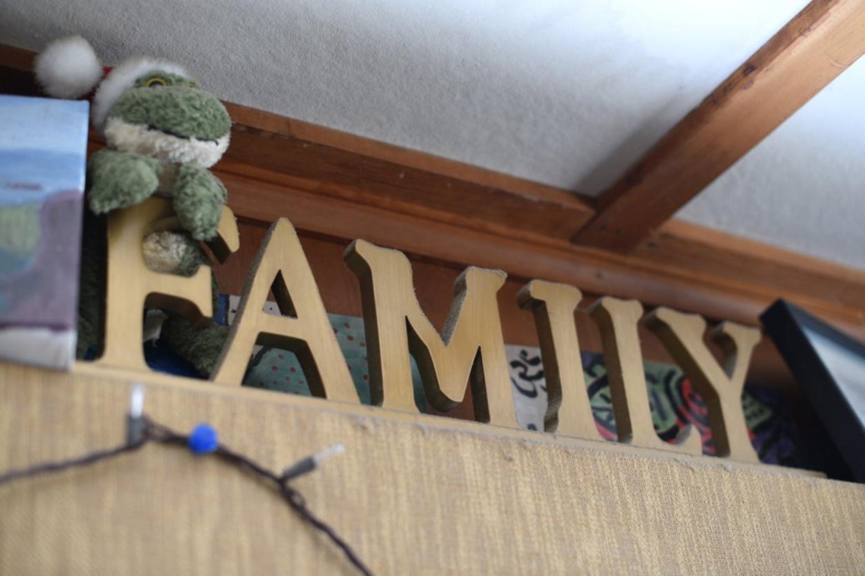 Letras doradas formando la palabra FAMILY en una estantería