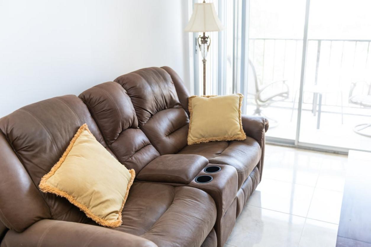 Sofá reclinable de cuero con posavasos