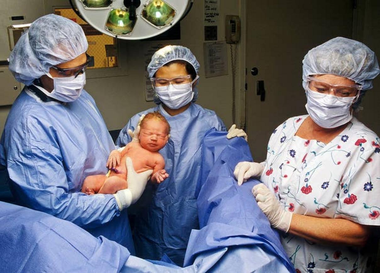 Equipo médico durante un parto en el quirófano
