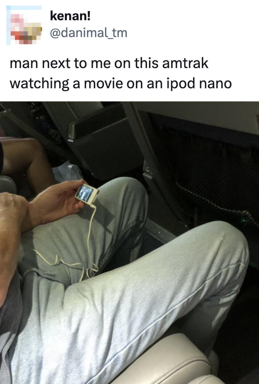 Persona viendo una película en un iPod en el tren