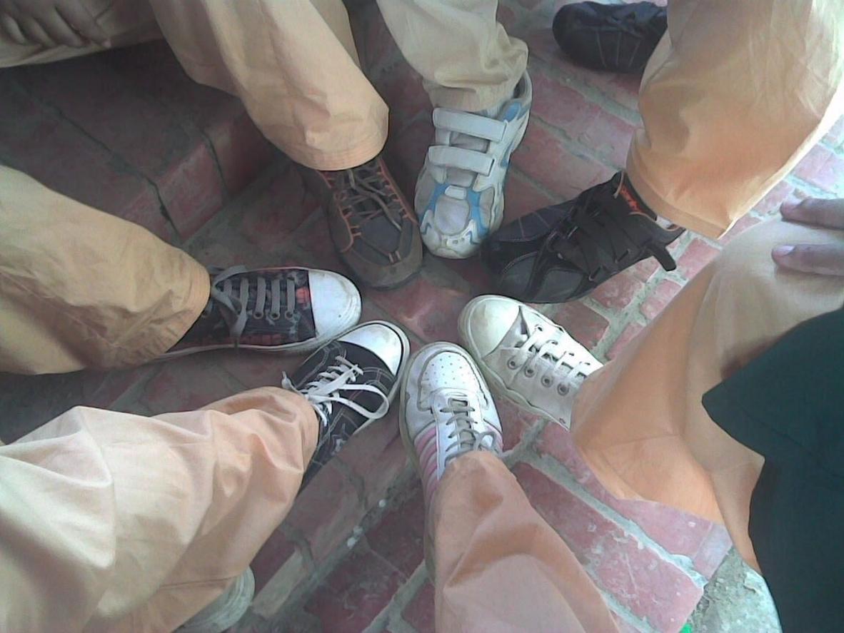 Seis pies en círculo llevando zapatillas Converse