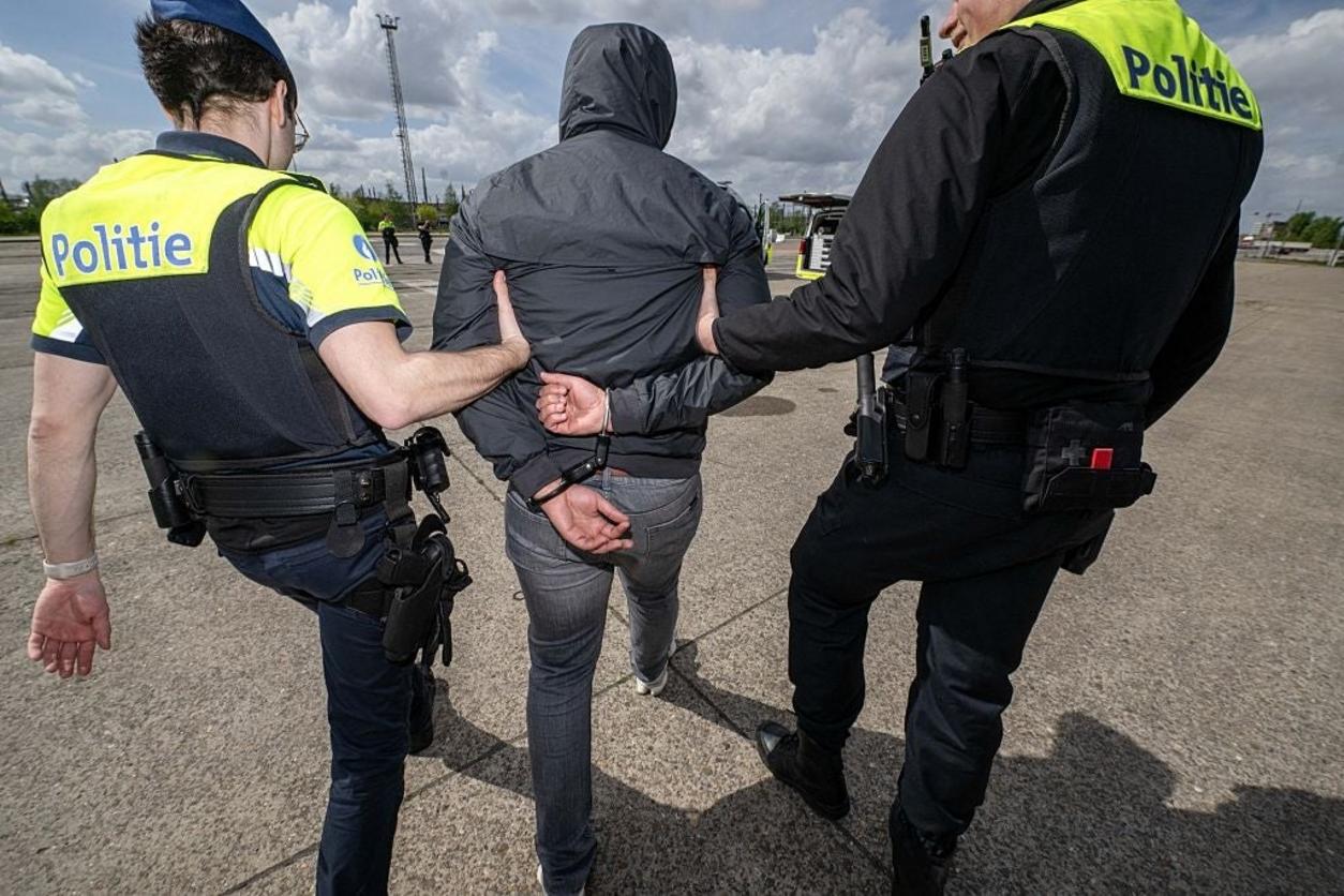 Hombre esposado por la policía
