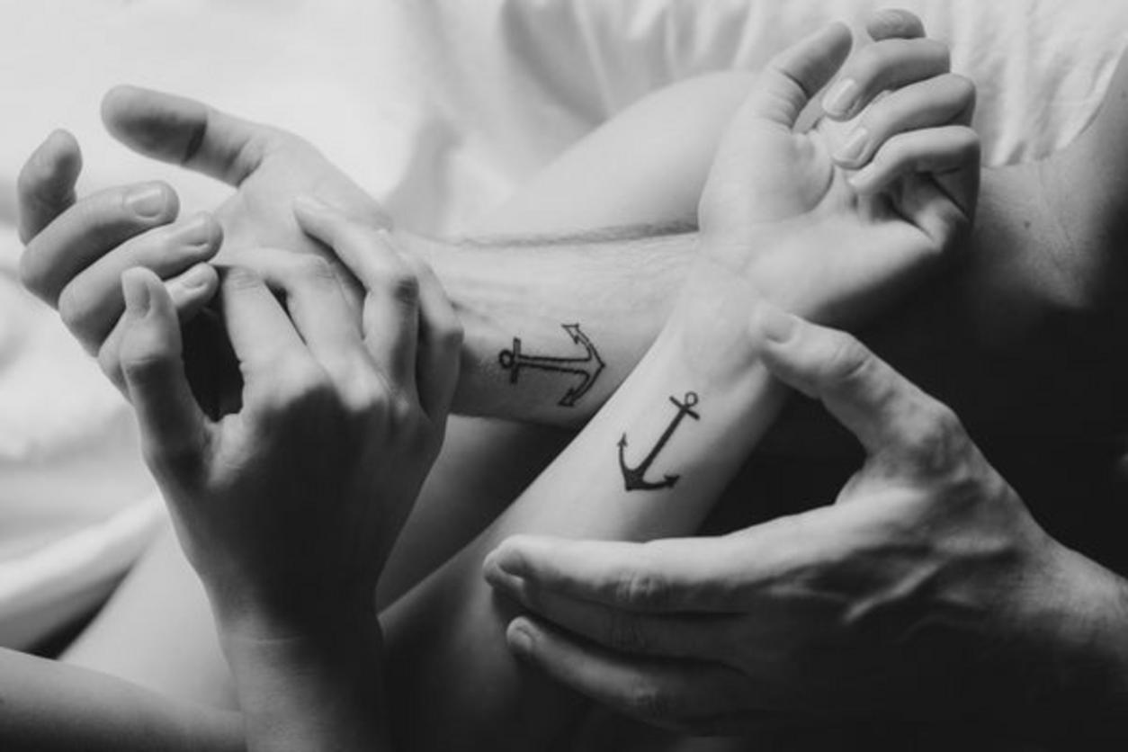 Tatuajes de anclas a juego en dos personas
