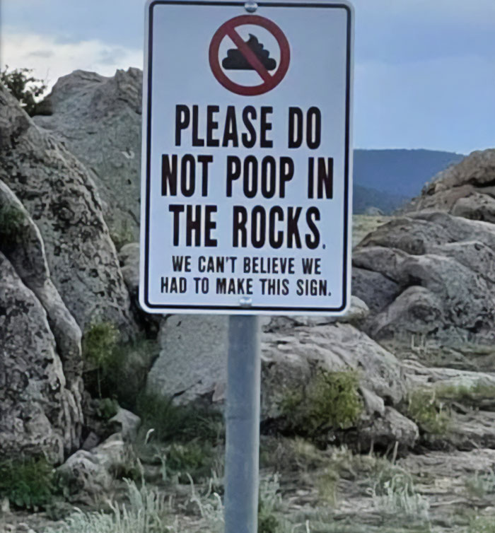 Cartel que pide no defecar entre las rocas y lamenta haber tenido que escribirlo