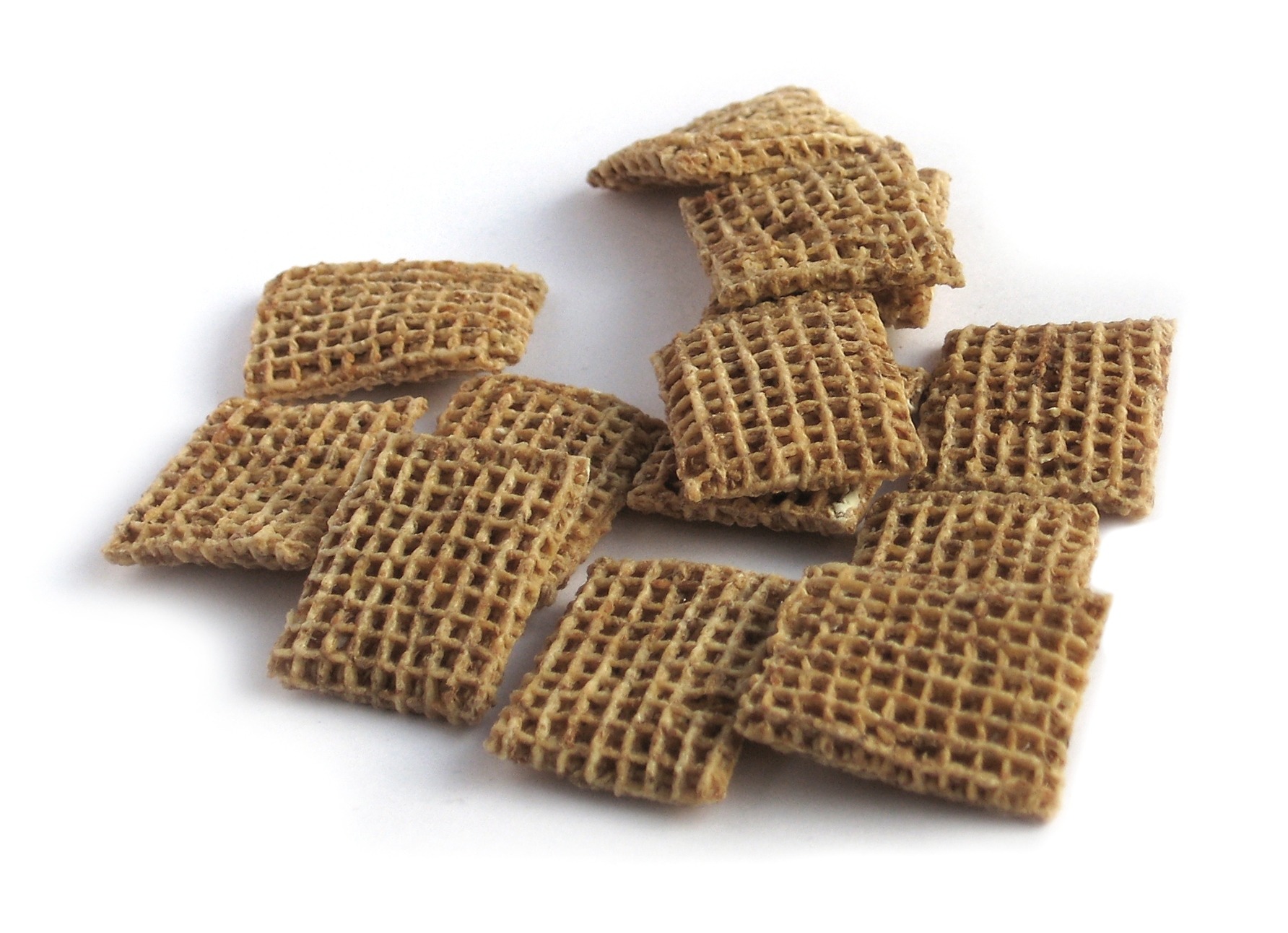 Piezas reales de cereal Shreddies, cuadrados de trigo integral con la superficie tejida en rejilla