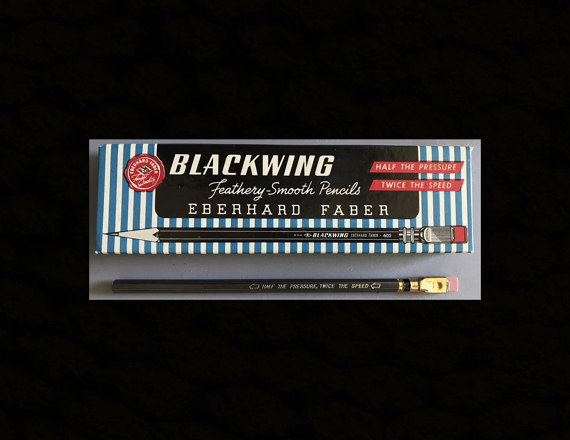 Caja gris de lápices Eberhard Faber Blackwing 602 con un lápiz gris oscuro de virola dorada y goma rosa