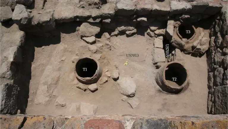 Tres bocas circulares de tonir abiertas en el suelo de una sala del castillo de Aruch, rodeadas de muros de piedra