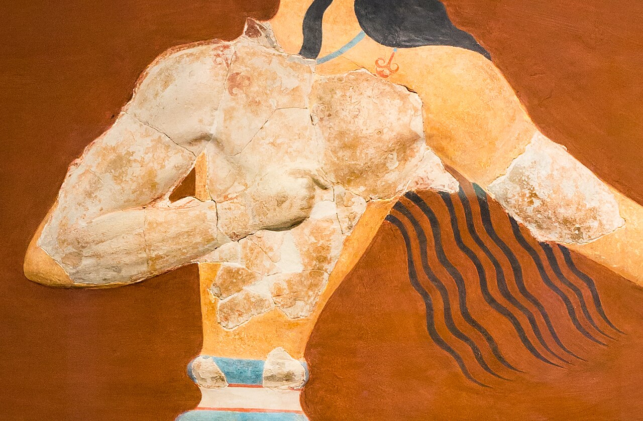 Detalle del torso del fresco: bloques de estuco agrietado en relieve rodeados de superficies lisas de color ocre y marrón