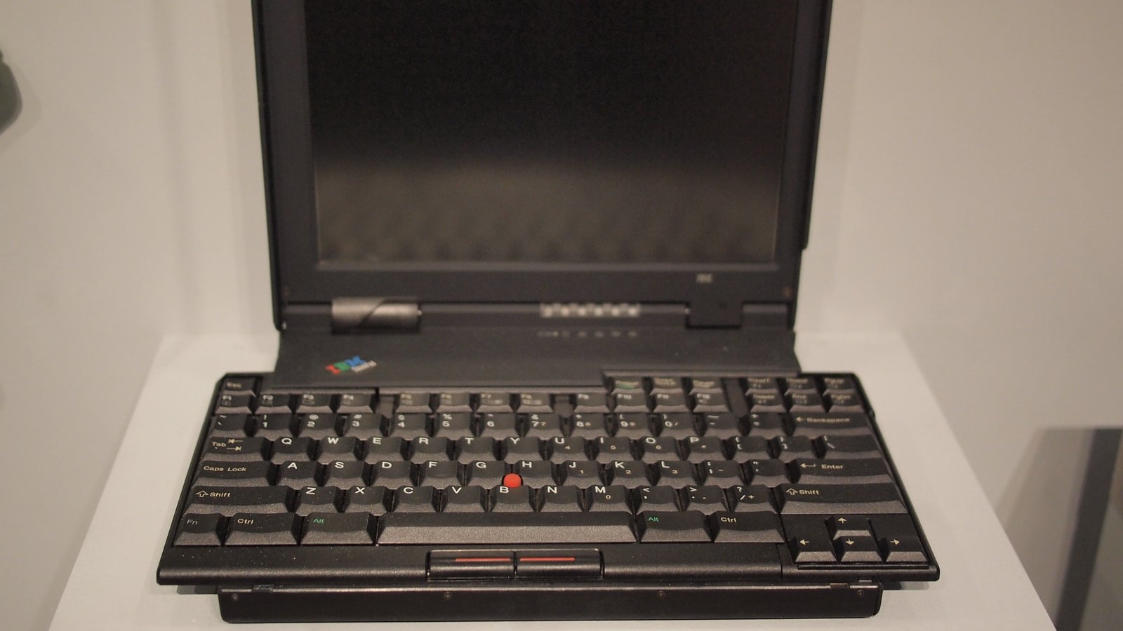 IBM ThinkPad 701 abierto en una vitrina, con su teclado mariposa desplegado y sobresaliendo por ambos lados de la carcasa